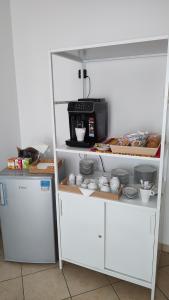 a white shelf with a microwave and some dishes at Borgo Levante Camere in Porto Viro