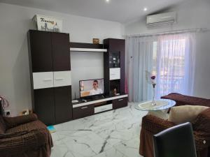 a living room with a flat screen tv on a cabinet at Jasmin Gardens in Paphos City