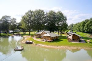 a group of tents and boats on a river at Glamping Betuwe in Kesteren