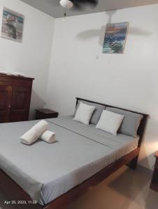 1 dormitorio con 1 cama con 2 almohadas en Garden Village Resort, en Moalboal