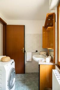 a bathroom with a washing machine and a sink at LEONI Apartment Bellagio in Bellagio
