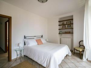 a white bedroom with a white bed and a chair at LEONI Apartment Bellagio in Bellagio