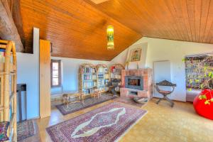 a living room with a fireplace and a wooden ceiling at Casa Dell'Antonio - Happy Rentals in Aranno