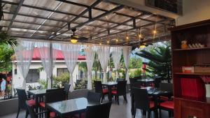 a dining room with tables and chairs and windows at Garden Village Resort in Moalboal