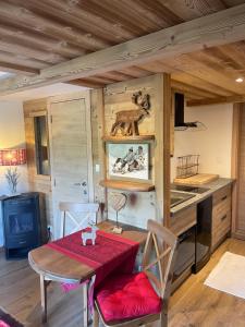 a dining room with a red table and chairs at Gite de Montagne "Calluna" 1 ou 2 pers in Xonrupt-Longemer