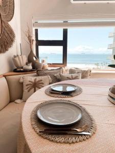a table with plates on it with a view of the ocean at Umdloti Boho Beach Villa in Umdloti