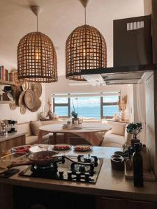 a kitchen with a view of the ocean and a table at Umdloti Boho Beach Villa in Umdloti