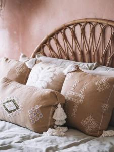un montón de almohadas sentadas encima de una cama en Umdloti Boho Beach Villa, en Umdloti
