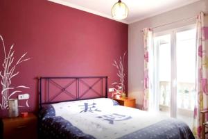 a bedroom with red walls and a bed with writing on it at Chalet zona relax in Palma de Mallorca