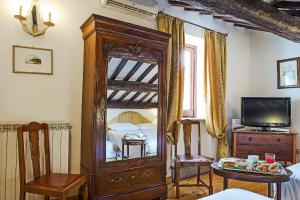 a large wooden grandfather clock in a room with a television at Hotel Fontana in Rome