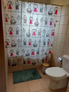 a bathroom with a toilet and a shower curtain at Pyla Palms Resorts A2 102 in Pyla