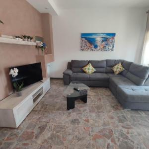 a living room with a couch and a tv at Attico Centrale Ostia 20 in Lido di Ostia