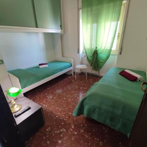 a small room with two beds and a window at Attico Centrale Ostia 20 in Lido di Ostia