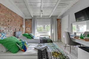 una camera con due letti e un muro di mattoni di Amber Baltic 2 by Grand Apartments a Gdynia