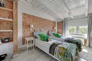 two beds in a room with a brick wall at Amber Baltic 2 by Grand Apartments in Gdynia