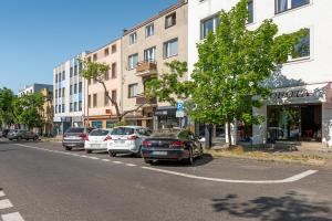 a row of cars parked on the side of a street at Amber Baltic 2 by Grand Apartments in Gdynia