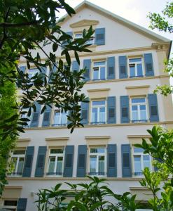 un edificio con persiane blu e alberi di Ferienwohnung Baden Baden a Baden-Baden