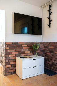 a brick wall with a tv above a white dresser at Spacious Apartment in urban location in Hamburg
