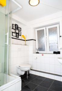 a white bathroom with a toilet and a sink at Spacious Apartment in urban location in Hamburg