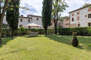 un cortile con un grande vaso nell'erba di Casale Mulin Bianco a Monteriggioni