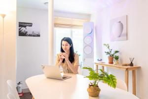 une femme assise à une table avec un ordinateur portable dans l'établissement Le Cocon Seoul, à Séoul