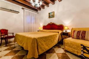 a bedroom with two beds and a chair and a chandelier at Hotel Ariel Silva in Venice