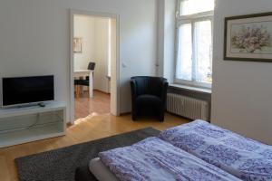 a bedroom with a bed and a flat screen tv at Ferienwohnung Baden Baden in Baden-Baden