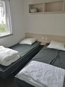 2 camas en una habitación con ventana en Mobile Home For You Quiberon en Quiberon