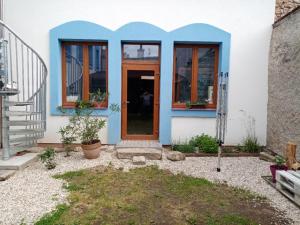 a blue and white house with a door at Penzion L´isola in Kunžak