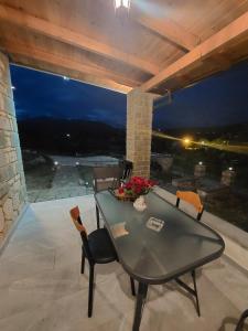 einen Tisch und Stühle auf einer Terrasse in der Nacht in der Unterkunft Persefoni's Home in Ioannina