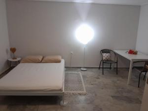 a bedroom with a bed and a table and a lamp at Cosy guesthouse-souterrain with garden in city center in Korinthos