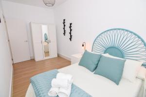 sypialnia z dużym łóżkiem z niebiesko-białymi poduszkami w obiekcie Apartamentos Atlantida w mieście Chipiona