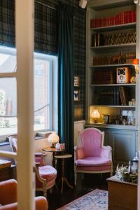 a living room with a pink chair and a window at La Maison d’Hôtes in Silly