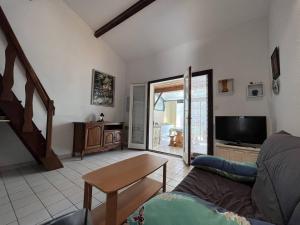 ein Wohnzimmer mit einem Sofa und einem TV in der Unterkunft Villa Saint-Cyprien, 2 pièces, 6 personnes - FR-1-106-88 in Saint-Cyprien