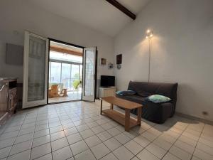 ein Wohnzimmer mit einem Sofa und einem Tisch in der Unterkunft Villa Saint-Cyprien, 2 pièces, 6 personnes - FR-1-106-88 in Saint-Cyprien