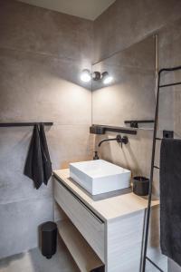 ein Badezimmer mit einem weißen Waschbecken und einem Spiegel in der Unterkunft Rousa little guesthouse Cosy Sky in Oberrasen
