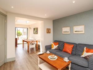 uma sala de estar com um sofá azul e uma mesa em Blanche Cottage em Weymouth