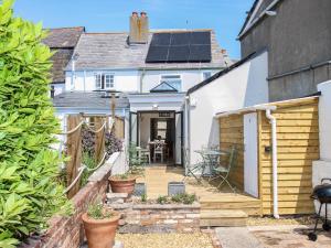 uma casa com telhado solar e um pátio em Blanche Cottage em Weymouth