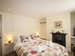 um quarto com uma cama grande e uma lareira em Blanche Cottage em Weymouth