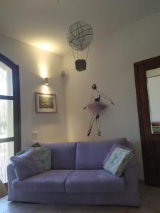 a living room with a purple couch and a basketball hoop on the wall at Marrubiu Resort Note di Stelle in Marrùbiu