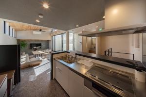 a kitchen with a stove and a living room at Besso姫路 in Himeji
