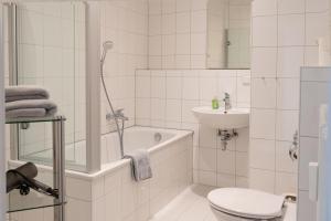 La salle de bains blanche est pourvue de toilettes et d'un lavabo. dans l'établissement Ferienwohnung Baden Baden, à Baden-Baden