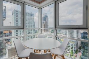 una mesa blanca y sillas en una habitación con ventanas en Platinum Towers J&K en Varsovia