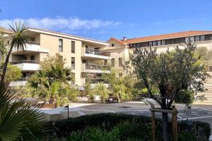 een appartementencomplex met een parkeerplaats en palmbomen bij Exclusive Resort Saint-Tropez in Saint-Tropez