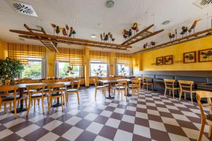 a restaurant with tables and chairs on a checkered floor at Dresdner Tor Süd in Wilsdruff