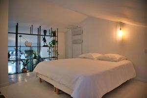 a bedroom with a white bed and a window at Appartement-Terrasse Centre Historique in Uzès