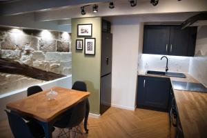 Appartement-Terrasse Centre Historique في ازيس: مطبخ مع طاولة خشبية ومغسلة ومكتب