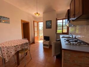 a kitchen with a table and a stove at Parco delle Ginestre in Portoferraio