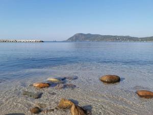 einen Strand mit einigen Felsen im Wasser in der Unterkunft Grand T2 60M² /Jardin 50M² plein sud /Mer à pieds in Saint-Mandrier-sur-Mer