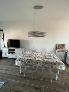 uma sala de jantar com uma mesa com cadeiras e um lustre em Claretta’s Home em Iglesias